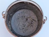 a pot with a handle on a white surface