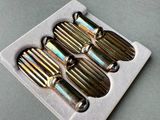 four silver spoons in a white tray on a table