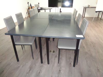 des tables et des chaises dans une pièce où est accrochée une télévision à écran plat au mur