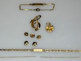 a lot of gold jewelry on a white surface