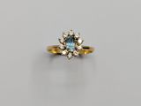a gold ring with a blue topaz stone surrounded by diamonds
