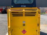 a yellow and black construction vehicle parked in a parking lot