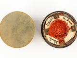 a small button that has a red seal on it