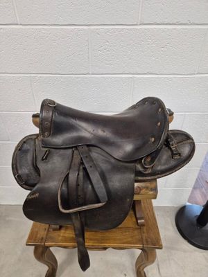 une selle et un chapeau posés sur un support dans une pièce