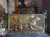 a metal plaque of a dog laying on the ground