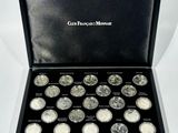 a black box filled with silver coins sitting on top of a white surface