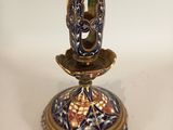 a gold and blue candle holder on a white table