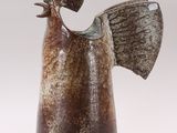 a brown and white vase with a bird on top of it