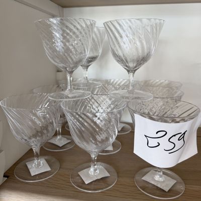 plusieurs verres à vin vides posés sur une étagère en bois