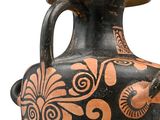 a black and orange vase with designs on it
