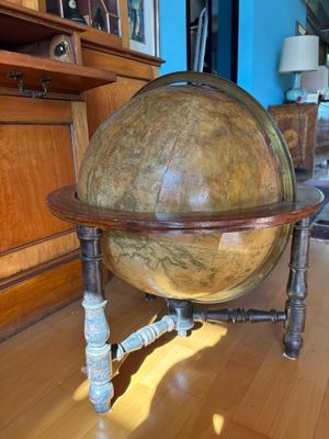 a large globe sitting on a wooden stand in a living room