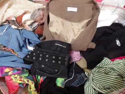 a pile of clothes that is sitting on a bed