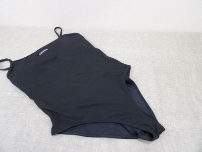 the back of a black tank top laying on a white surface