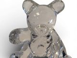 un ours en peluche en verre posé sur une surface blanche