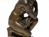 an image of a bronze statue of a man sitting on a pedestal