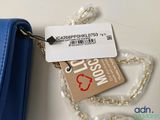 a blue purse with a tag attached to it