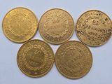 four different types of gold coins on a white surface