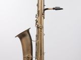 an old brass saxophone sitting on top of a white surface