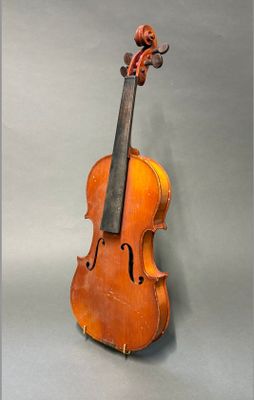 un vieux violon posé sur une table près d'un mur gris