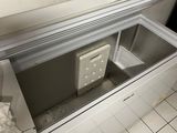 a small refrigerator in the middle of a tiled floor
