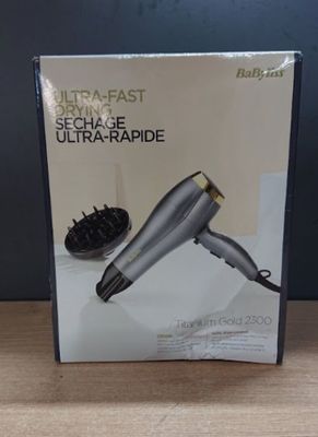 packaging of a hair dryer sitting on a table with a hair dryer in the background
