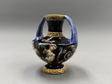un vase bleu et or posé sur une table