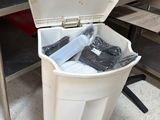une personne qui jette quelque chose dans une poubelle