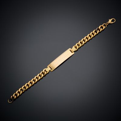 un bracelet en or composé d'une barre et d'une chaîne sur fond noir