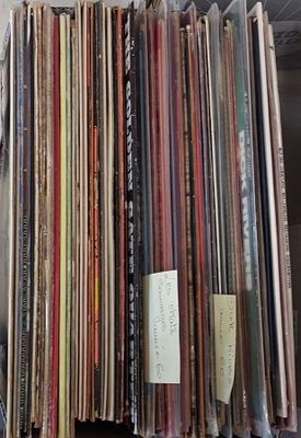 a lot of records stacked on a shelf in a room