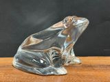an image of a glass frog sitting on top of a wooden table