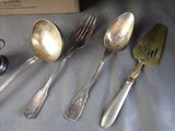 four spoons, a fork, and a spatula on a table