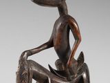 an image of a wooden sculpture of a man sitting on a horse