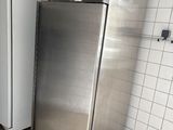 des réfrigérateurs en acier inoxydable dans des toilettes publiques aux murs carrelés