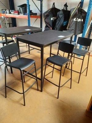 une table et des chaises dans une pièce où est accroché un sac à dos au mur