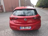 the back end of a red car parked on the side of a road