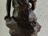 a statue of a man sitting on top of a rock