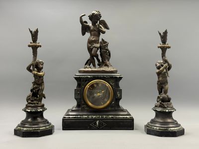 trois statues représentant un homme et une femme avec une horloge