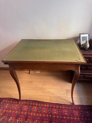 une petite table au plateau vert dans un salon