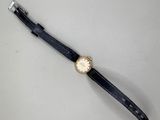 une image représentant une montre posée sur une table, sur fond blanc
