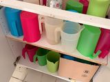 une étagère sur laquelle sont posées des tasses et des mugs dans la salle de bains