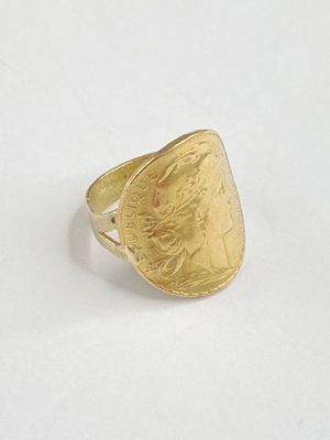 gros plan d'une bague en or sur une surface blanche