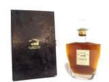 une vieille bouteille de whisky posée à côté d'une boîte noire