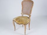 an old chair with a yellow seat and a cane back
