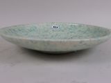 a small green bowl with a small sticker on it