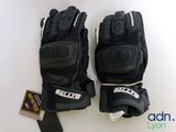 two pairs of black gloves with white logos on them sitting on a white surface