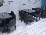 tables and chairs are lined up in a restaurant with a mural on the wall