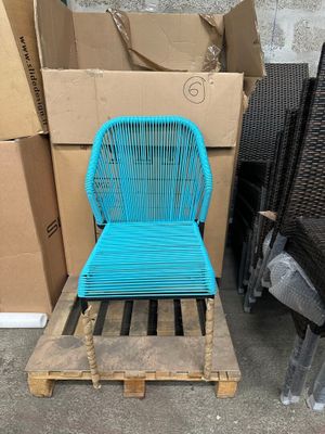 une chaise bleue posée sur une palette, à côté d'une pile de cartons