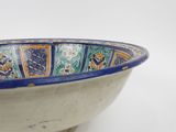 a blue and orange bowl sitting on a white surface