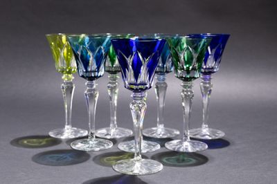six verres à vin sont alignés sur une surface grise