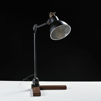 un gros plan d'une lampe de bureau posée sur un pied en bois